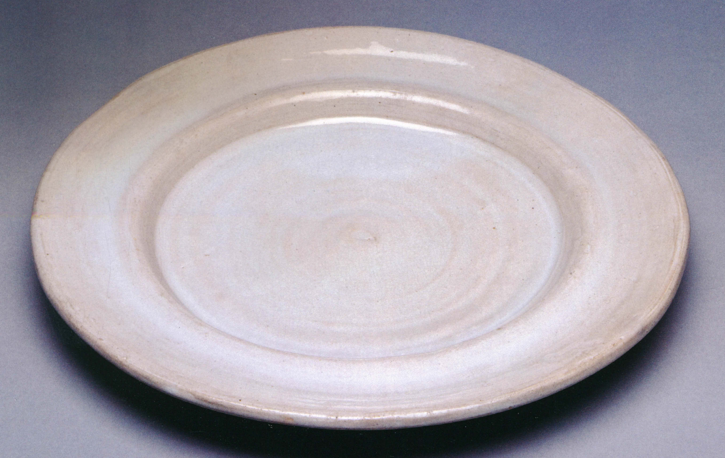 about 1914–16, earthenware with white tin glaze, 30.48 cm diameter, private collection. 