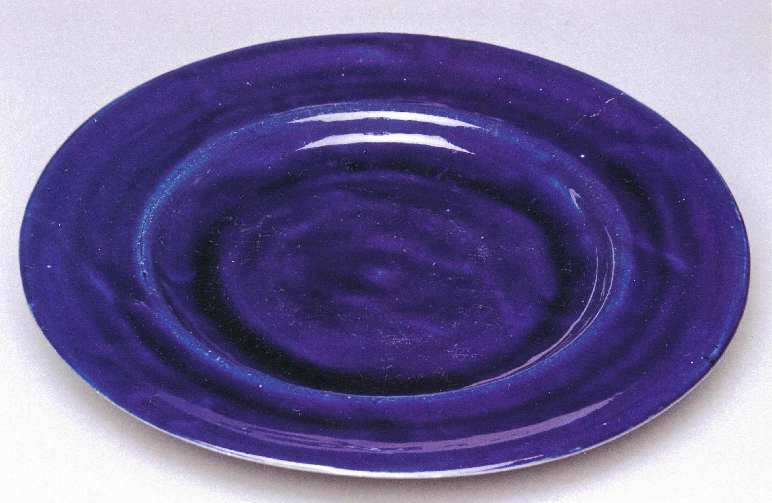 about 1914–16, earthenware with cobalt blue glaze, 25.4 cm diameter, private collection.