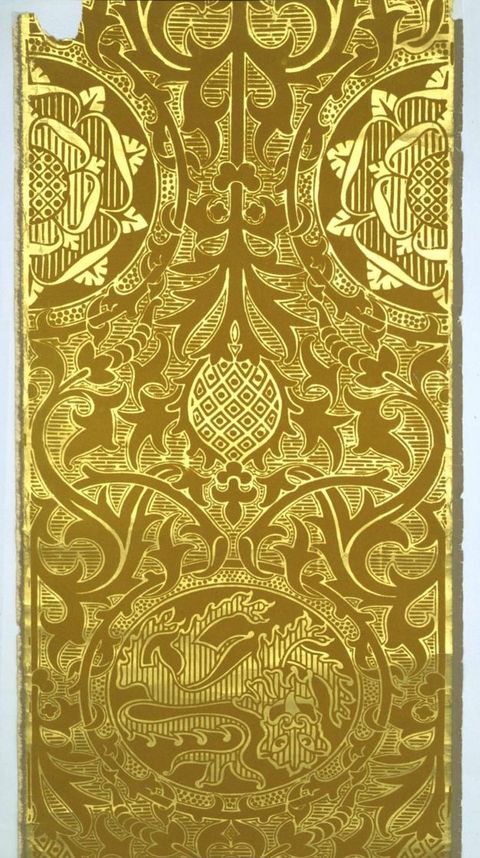 Print. In shiny gold against a harvest yellow background, stylized rosettes and heraldic lions are surrounded by leafy vines.
