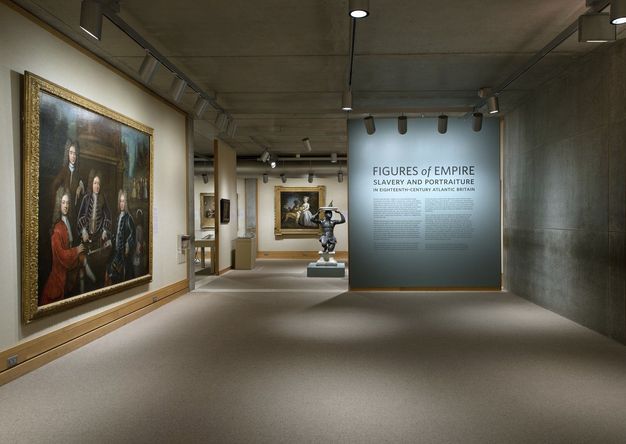 Installation photograph. This view of an exhibition includes the introductory wall panel. At the top, the largest letters read, 'Figures of Empire'. In letters about half as high, the subtitle below reads, 'Slavery and Portraiture', and in smaller text, 'in eighteenth-century Atlantic Britain'.