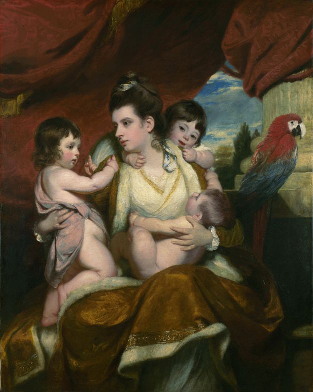 Painting. A woman holds a nude baby to her chest as two more small boys clutch her shoulders, all nestled on her deep gold-coloured, fur-lined cape. They all have pale skin and brown hair, except the baby whose hair is a shade lighter. A red, blue, and white parrot sits to our right.