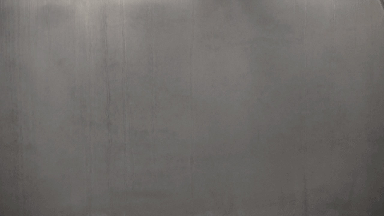 Black and white animation. Photographs are animated in a short loop so that we pan across a lightly streaked concrete wall.