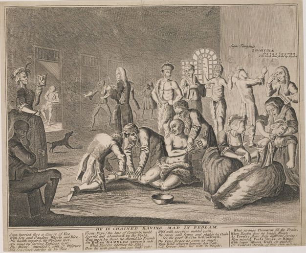Print. Twelve men and three women gather in a shallow space against a deep room lined with cells. At the centre of this group, two men attach a manacle around a third man’s leg. Another man draws gridded globes on a wall to our right.