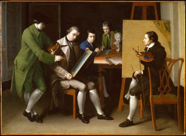 Painting. Three men and two boys, all with pale skin, gather in an artist’s studio. A man wearing a grass-green suit to our left holds a paint palette and brushes, and points to a drawing held by another man.
