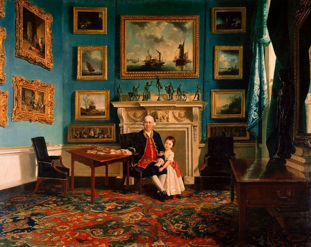 Painting. An older man with sagging jowls and bags under his eyes sits at a letter-writing table in front of a hearth. A young child stands by his knee and hooks one hand around the older man’s arm. Seven bronze statuettes line the mantle and genre paintings, land- and seascapes in carved, gilded frames fill the wall around the hearth.