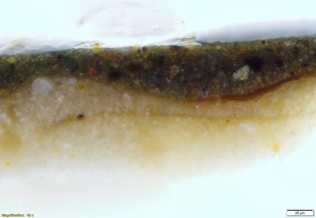 Colour photograph. In this microscopic cross section of paint, a white layer across the bottom gives way to golden yellow. Text in the lower left corner reads, “Magnification: 40x”, and in the lower right, “20µm”.