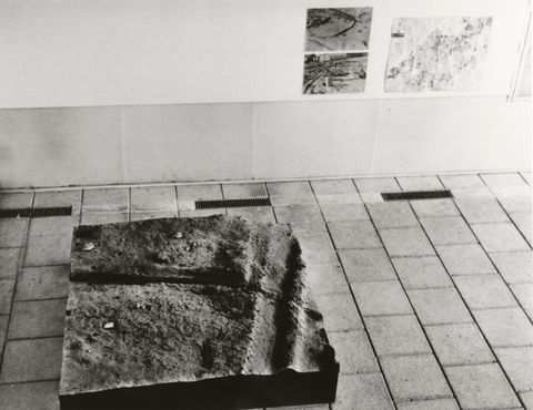 Installation photograph. Black and white photograph shows a panel of resin that had been cast over a square area of dirt.