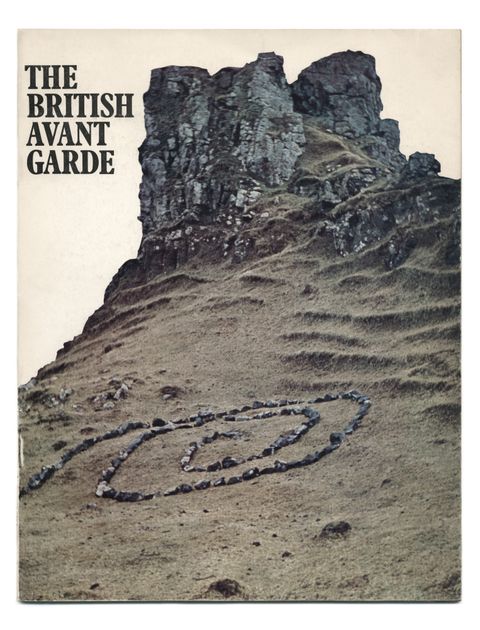 Cover of an exhibition catalogue. Grey stones have been arranged in a spiral on the steep incline leading up to rocky cliffs.