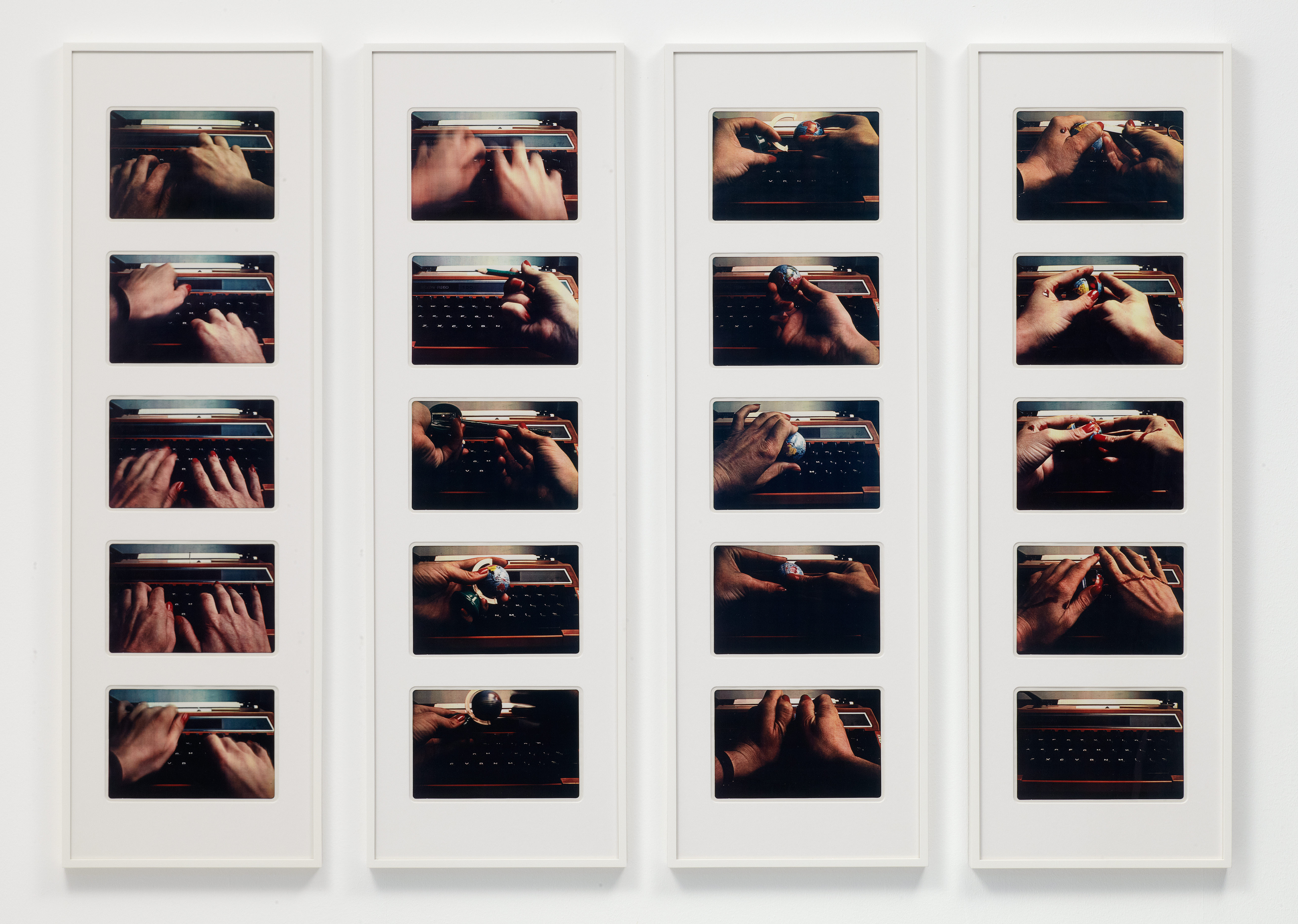 Installation photograph. Twenty photographs show a woman’s hands working the keyboard and mechanics of a typewriter, except the last image, which shows the typewriter in shadow. The photographs are framed in columns of five.