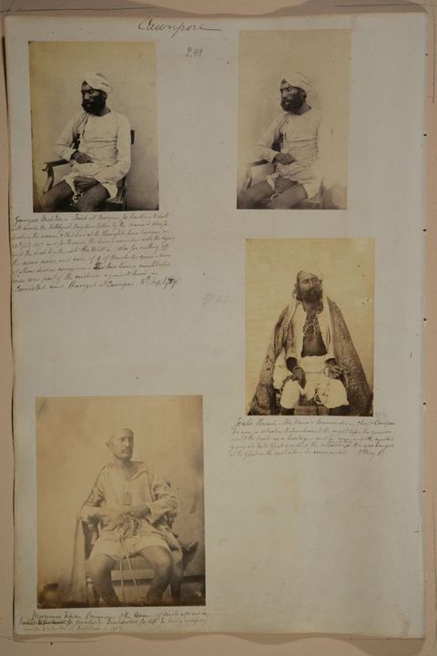 Page of a book. Four black and white portraits of men with dark skin sitting with their hands chained. Lines of handwritten notes are under three of the photographs.