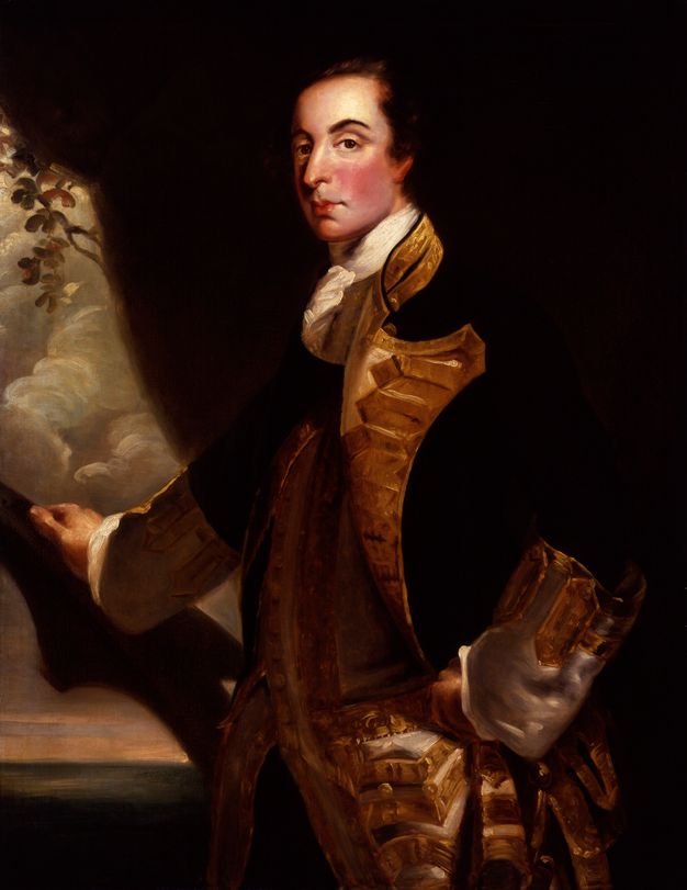 Painting. Shown from the hips up, a pale-skinned man stands in front of a seaside landscape with his body facing our left. He turns his face to look at us from under a cocked, dark eyebrow, his lips pursed. His dark hair blends into the rock behind him. His military coat has wide, gold lapels and cuffs, and it falls open over a gold waistcoat.