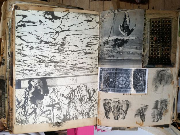 Pages of a book. Five black and white images are pasted onto yellowed pages. The image on the right shows Jackson Pollock crouching by a canvas on the floor, paint can in hand. The facing page has illustrations of historic costumes, a drawing, a rug, and other works.