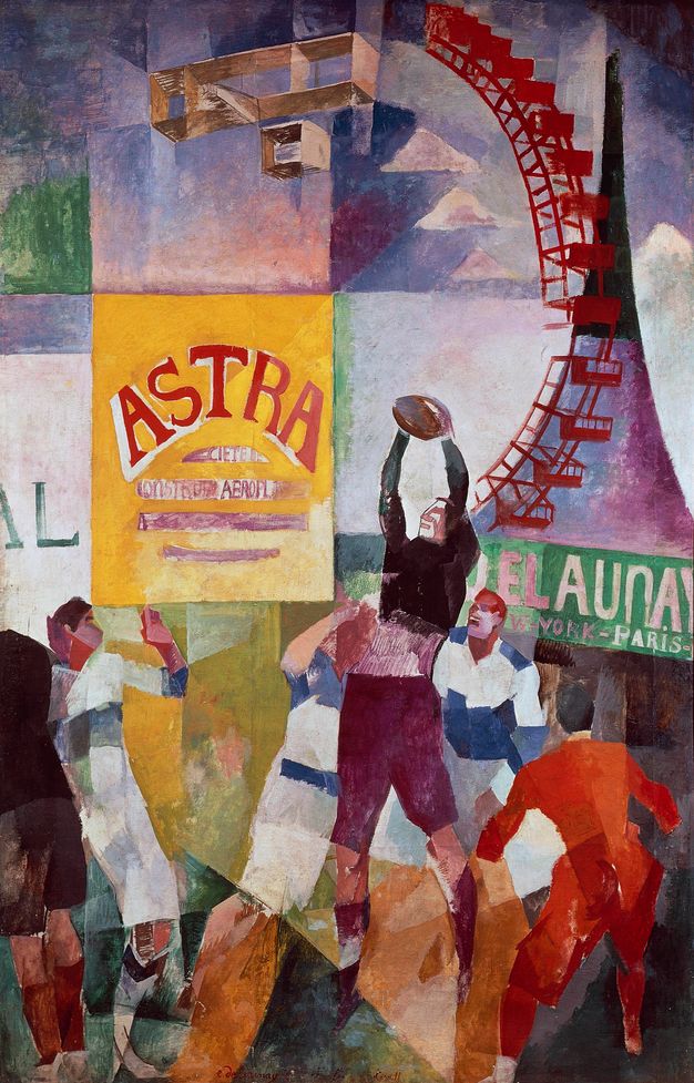 Painting. Rugby players scuffle in front of a dream-like array of imagery. An arc of a red Ferris wheel is in the upper right next to a boxy biplane. A sign near the centre reads “Astra” in red letters against a yellow background. A sign in the style of New York City street signs, with white all caps letters against a green background, reads “Delaunay New York Paris” to our right.