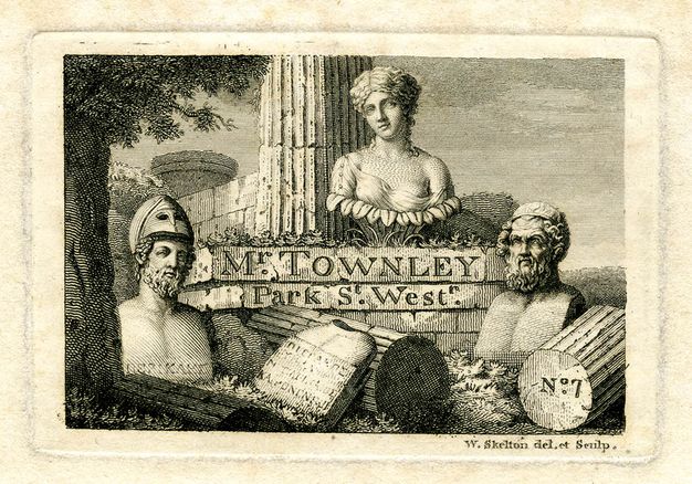 Print. Black lines on cream paper show three classical busts arranged at the base of a ruined column overgrown with vegetaion. Fragments of the column, and a tablet with an illegible inscription, surround them. On the base of the column, text reads “Mr. Townley Park St. West”.
