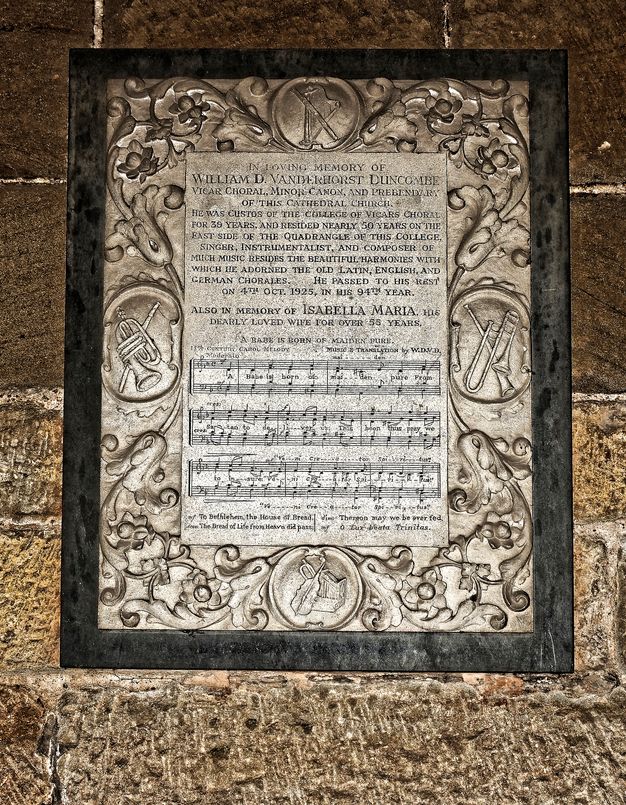 Black and white photograph. We look down onto a nave, which is packed with people. Text is printed in white against black above and below.