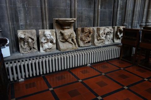 Architectural features. Carved from stone, men and women stoop or twist against flat backgrounds in these six corbels, which are displayed on a long window ledge inside a church.
