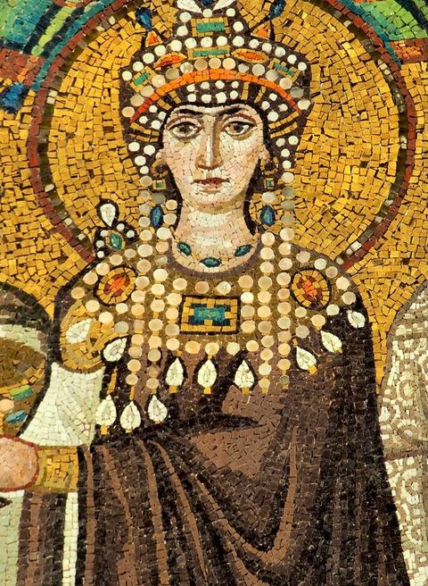 Mosaic. Detail view of a woman wearing a brown robe or cloak, a broad decorated collar and a jewelled headdress. She has pale skin, and her head is surrounded by a halo.