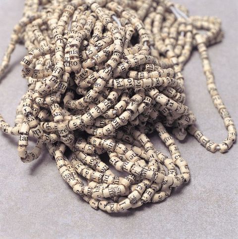 Sculpture. Paper with text printed on it has been cut into strips and rolled into beads, which have then been strung together.