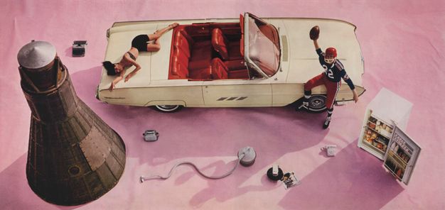 Colour photograph. We look down onto a cream-white convertible with a red interior, a space capsule, an open refrigerator, a telephone, a toaster, and a vacuum cleaner arranged on a mauve-pink cloth. An American football player sits on the hood of the car, holding up a ball, and a woman sprawls on the trunk.