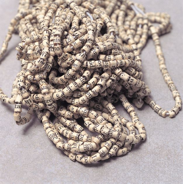Sculpture. Paper with text printed on it has been cut into strips and rolled into beads, which have then been strung together.