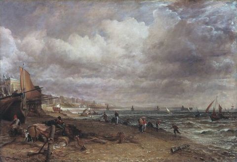 Painting. Waves lap against a beach under cloud-filled skies. A rowboat and at least one sailboat have been pulled up onto the beach to our left. Men and a dog sit and work there. More people walk along the beach, which angles from the lower right corner into the distance to our left. A line of buildings further up the shore blends into a distant bridge along the horizon, which comes about a third of the way up this canvas.