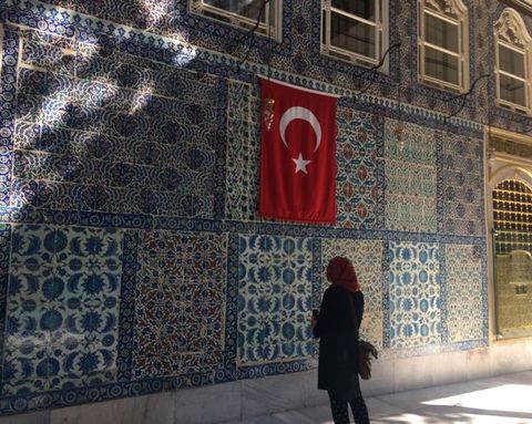 Architecture. Panels of intricately patterned tiles in mostly blue with touches of green, red, or yellow fill this wall.