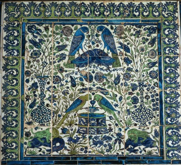 Tiles. Sixteen tiles in a grid of four by four are painted with a vertically, mostly symmetrical design of birds, animals, flowers, vases, and one person in tones of intense blue and green against a white background.