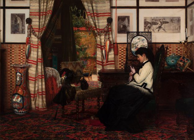 Painting. A woman wearing a black skirt and white jacket sits facing our left in profile in a room layered with pattern. Black and white pictures are hung frame-to-frame in two rows across the top half of the wall. The bottom half is checked with red, black, and gold. Striped curtains open onto a shadowy space with a garden beyond it.