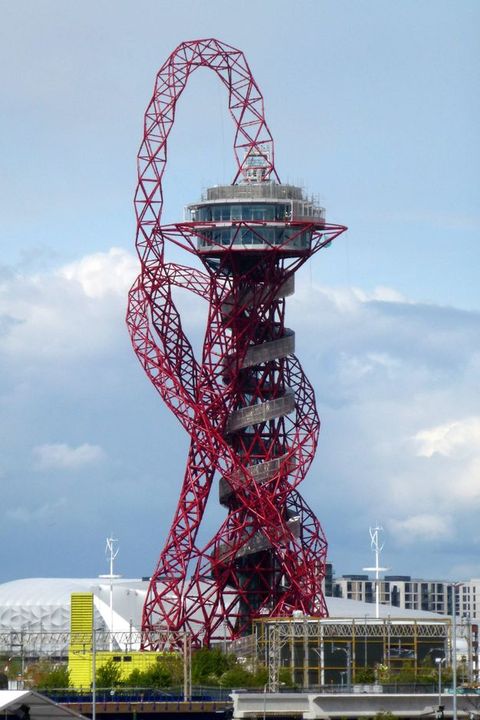Architecture. A structure like a space needle has a round observation deck on a tall, narrow base. The base spirals up, seeming to hide the structure that must hold the deck up. A net-like tube spews up from the top and turns around the rest the structure like a tangled necklace.