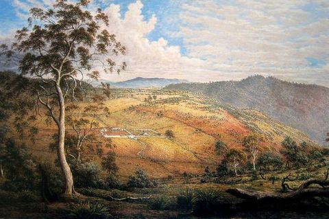 Painting. We look down into a valley and at the face of a hill across from us. The ground near us has sage-green growth and trees, and the hill is tinged with orange and yellow. A white outline suggests a building complex in the distance.