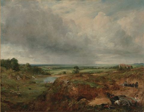 Painting. A pond nestles among in a grassy area beyond a flat-topped promontory in this landscape. The horizon comes just under halfway up this composition. Banks of steel-blue clouds sweep across the flat land above, and rain falls in the far distance.