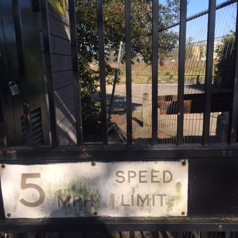 Sign on an iron gate reads “5 MPH Speed Limit”.