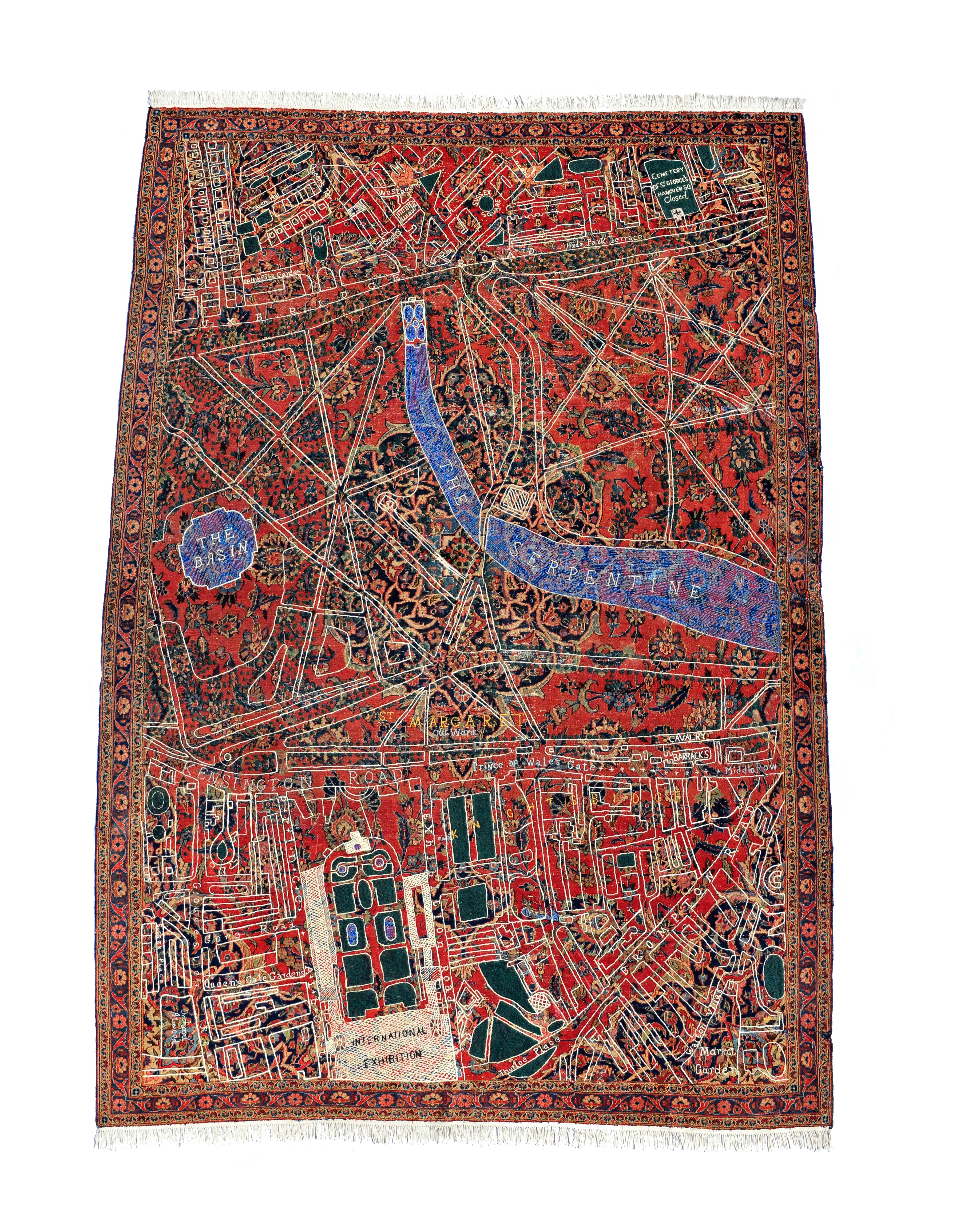 Textile. A map of Hyde Park is embroidered over a carpet patterned with red, black, peach, and green in floral designs. The map is mostly white for the streets, walkways, and buildings, and blue for areas labelled “The Basin” and “The Serpentine”.