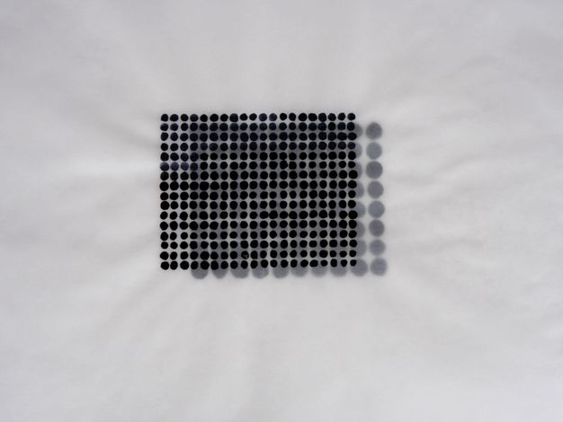 Painting. A grid of black dots, twenty across and sixteen down, is painted on tracing paper. This translucent sheet is laid over another painted with a grid of ten by eight dots. Each dot on the second page is twice as big as those in the first set.