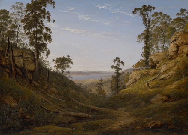 Painting. Grassy hills dotted with boulders rise to either side of a valley that extends into the distance in this horizontal landscape. A flat expanse beyond leads to a body of water in the distance. A few wispy white clouds flick across the blue sky.