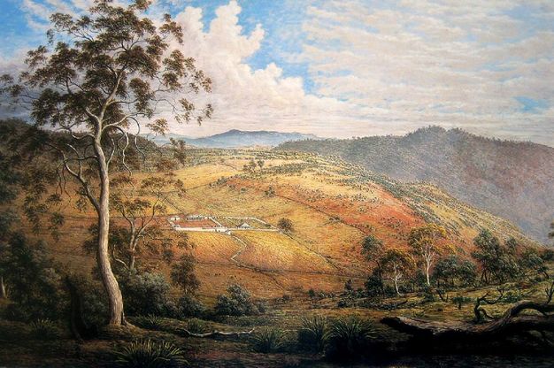 Painting. We look down into a valley and at the face of a hill across from us. The ground near us has sage-green growth and trees, and the hill is tinged with orange and yellow. A white outline suggests a building complex in the distance.