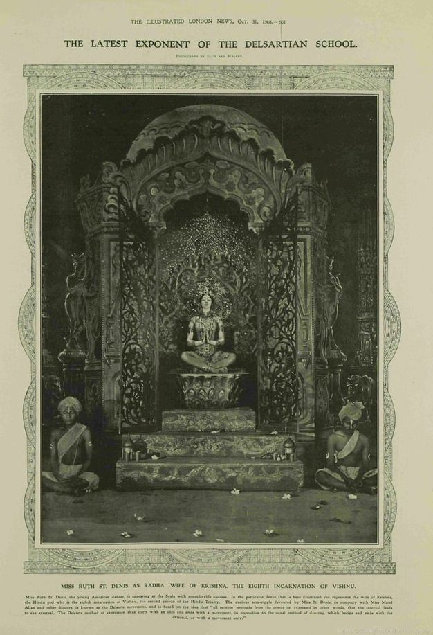 Page of a magazine. A black and white photograph of a woman and two men in Indian costumes who all sit on an elaborate set. Text along the top of the issue reads, “The Illustrated London News, Oct. 31 1908 The Latest Exponent of the Delsartian School”.