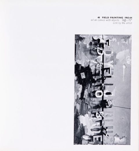 Page from a book. Black and white illustration of a tall vertical composition. A dark line drops down the middle, and three words are mirrored to each side. They read “red yellow blue”. Some letters are sculpturally three-dimensional and stand out from the canvas, and some letters are painted amid streaks and slashes on the canvas. The caption above reads, “48 Field Painting 1963-64 oil on canvas with objects 36 ¾ x 72” Lent by the artist”.
