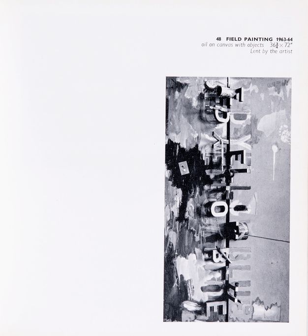 Page from a book. Black and white illustration of a tall vertical composition. A dark line drops down the middle, and three words are mirrored to each side. They read “red yellow blue”. Some letters are sculpturally three-dimensional and stand out from the canvas, and some letters are painted amid streaks and slashes on the canvas. The caption above reads, “48 Field Painting 1963-64 oil on canvas with objects 36 ¾ x 72” Lent by the artist”.