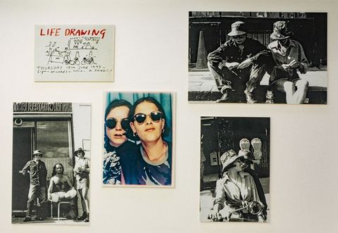 Installation. Three black and white photographs, a colour snapshot as from a photo booth, and a drawing are displayed against a white background.