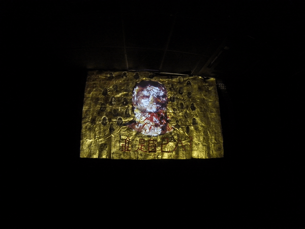 Video gif. Red lines spatter from a face shown against a gold field.