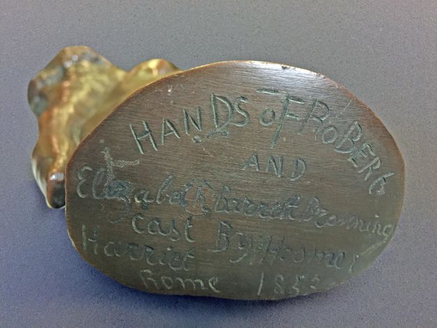 Sculpture. We look at the flat, oval end of a bronze sculpture.