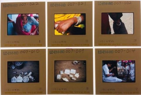 Slides. Four colour slides show close ups of an ear with rings hanging over the upper helix, silver cuff bracelets on dark-skinned arms, the lower legs and shoes of a person standing next to a bicycle, and a red turban catching light in an otherwise shadowy picture.