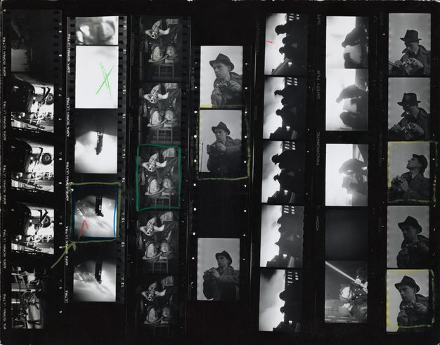 Photographic contact sheet. Seven strips of black and white film show firefighters working and the photographer, camera poised. Five images are outlined in yellow or green, and one has a red check mark.
