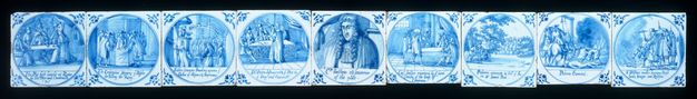 Tiles. Nine tiles painted blue against white show groups of people or, for the one in the centre, a portrait of a single person. Details in the pictures and writing under each are difficult to make out in this image.