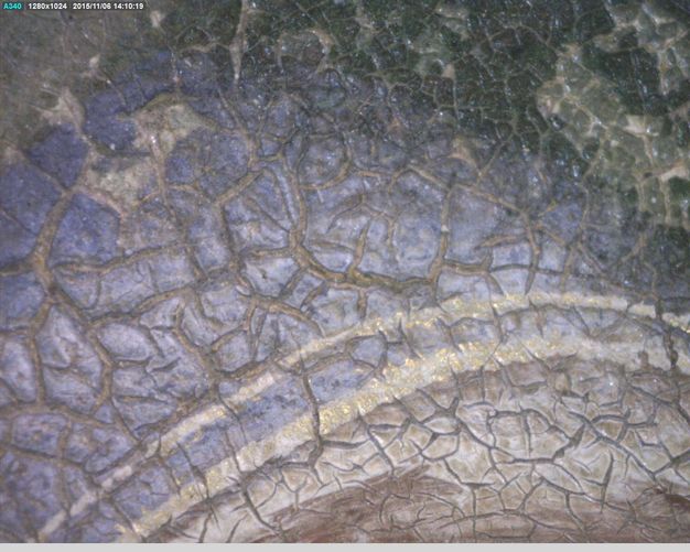 Painting. Detail view of a cracked painted surface with two bands glimmering faintly with gold against delphinium blue.