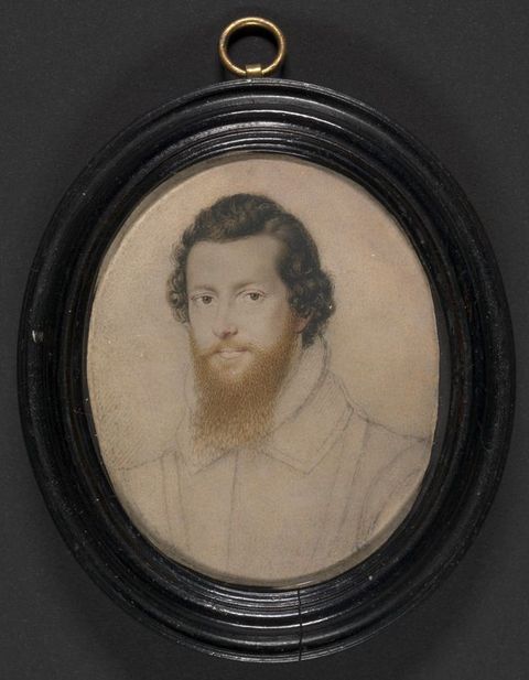 Watercolour. The pale face, chestnut-brown hair, and ginger beard of a man are painted in detail. His costume is sketched in. The oval portrait is in a wood frame.