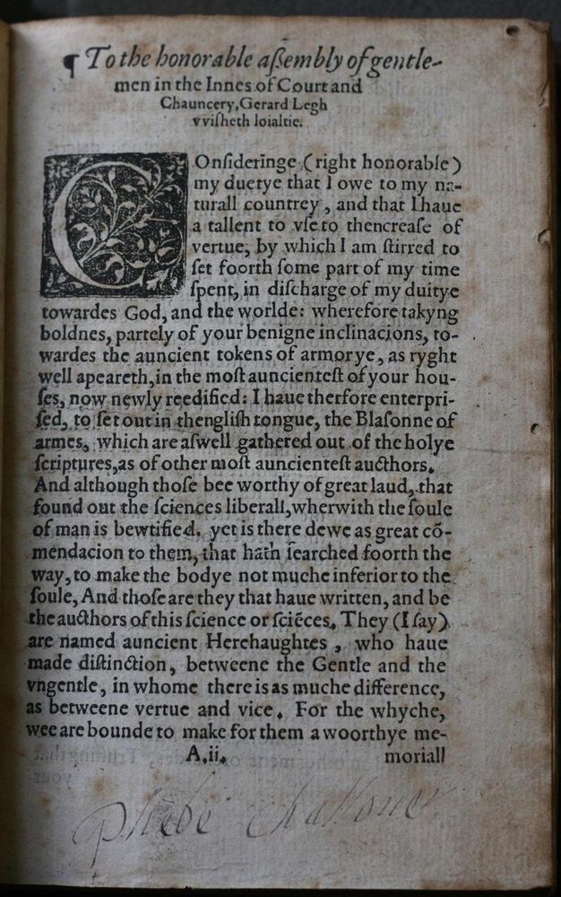 Page of a book. The heading reads, “To the honorable assembly of gentlemen in the Inns of Court and Chauncery”. Text follows a drop case ornamental letter C. The name “Phebe Challoner” is written in pen across the bottom of the page.