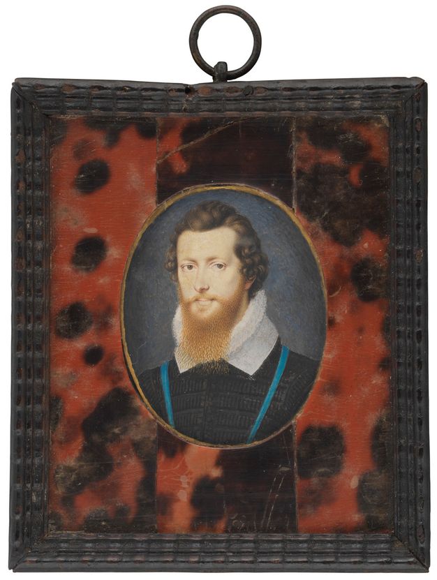 Watercolour. A pale-skinned man is shown from the chest up against a slate-blue background. His chestnut-brown curls are brushed back from his hairline, and his ginger-red beard overlaps the pleated ruff and lacy collar he wears. He has dark eyes and delicate pink lips. The rectangular frame has an oval opening.
