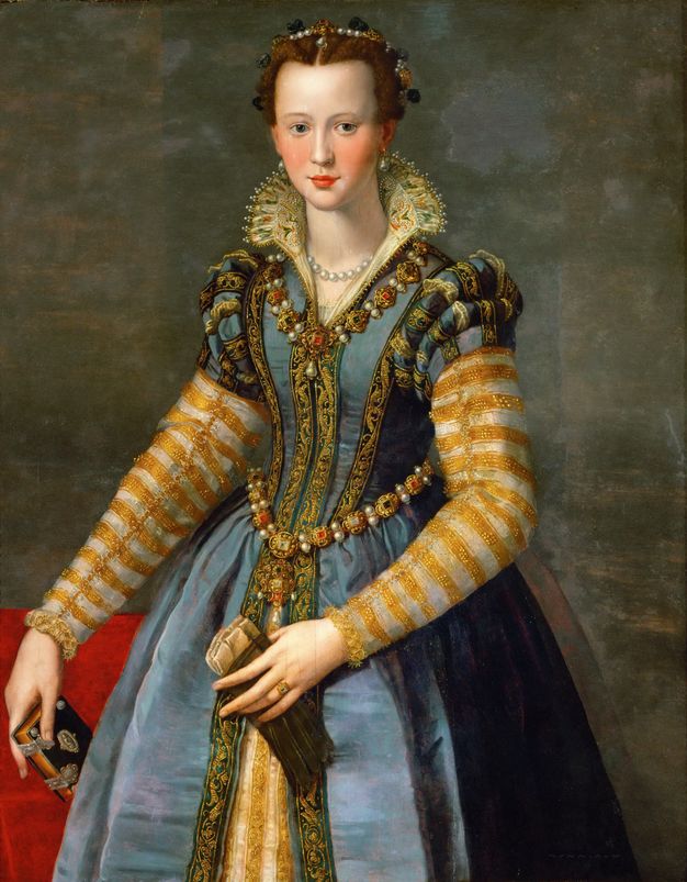 Painting. Shown from the knees up, a pale-skinned woman’s cheeks flush pink and her red bow-shaped lips slightly smile. A pearl diadem tucks into her auburn hair, which is pulled back. Her gown is laden with gems and pearls in gold fittings and with gold-edged and patterned fabric. She holds a postcard-sized book in one hand and a pair of gloves in the other.